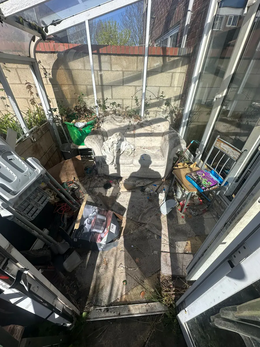 Cluttered conservatory before Mukin clearance