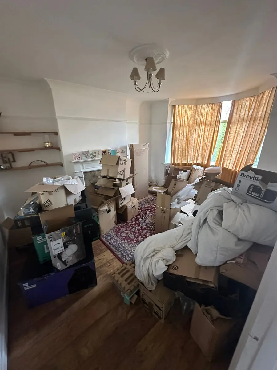 Living room full of boxes and bedding before Mukin house clearance