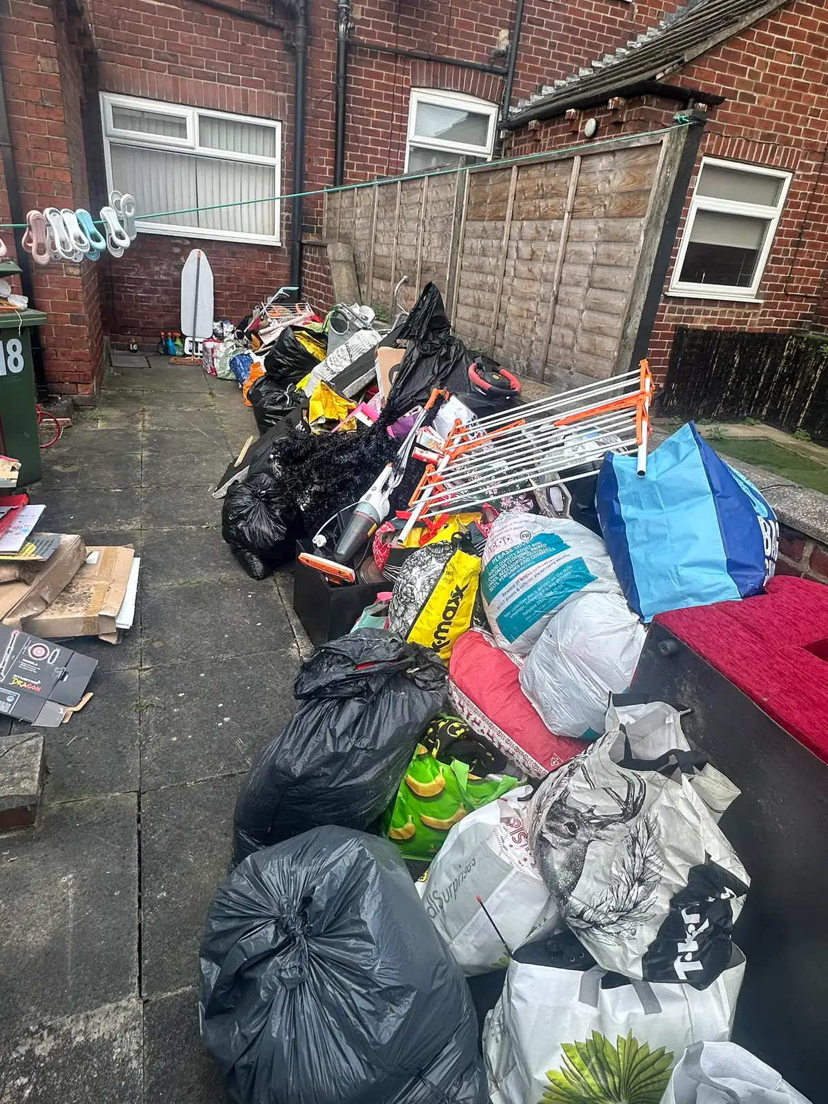 Backyard pile of bin bags, mattresses and household clutter from a Mukin house clearance in York