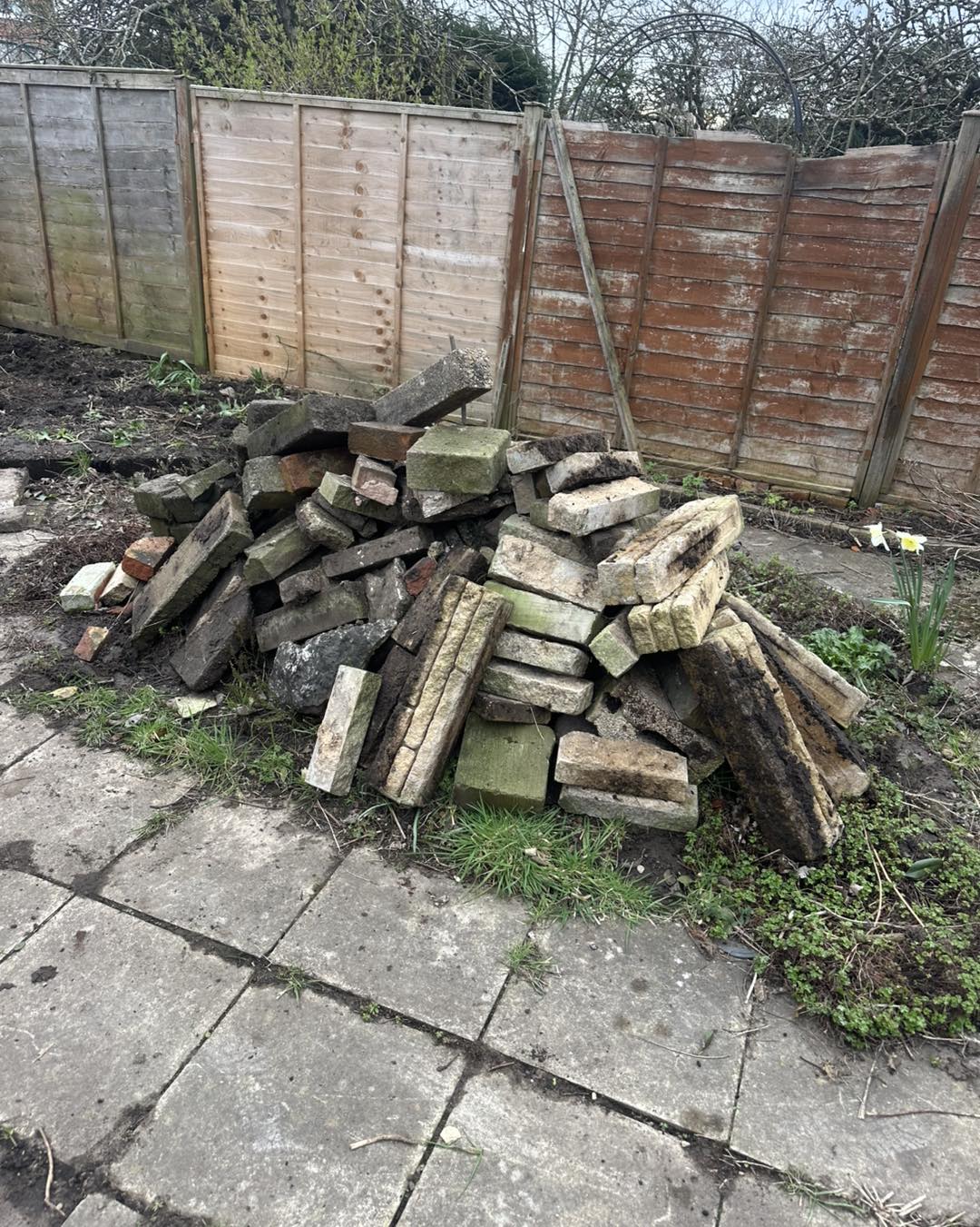 Pile of bricks and rubble in garden before collection