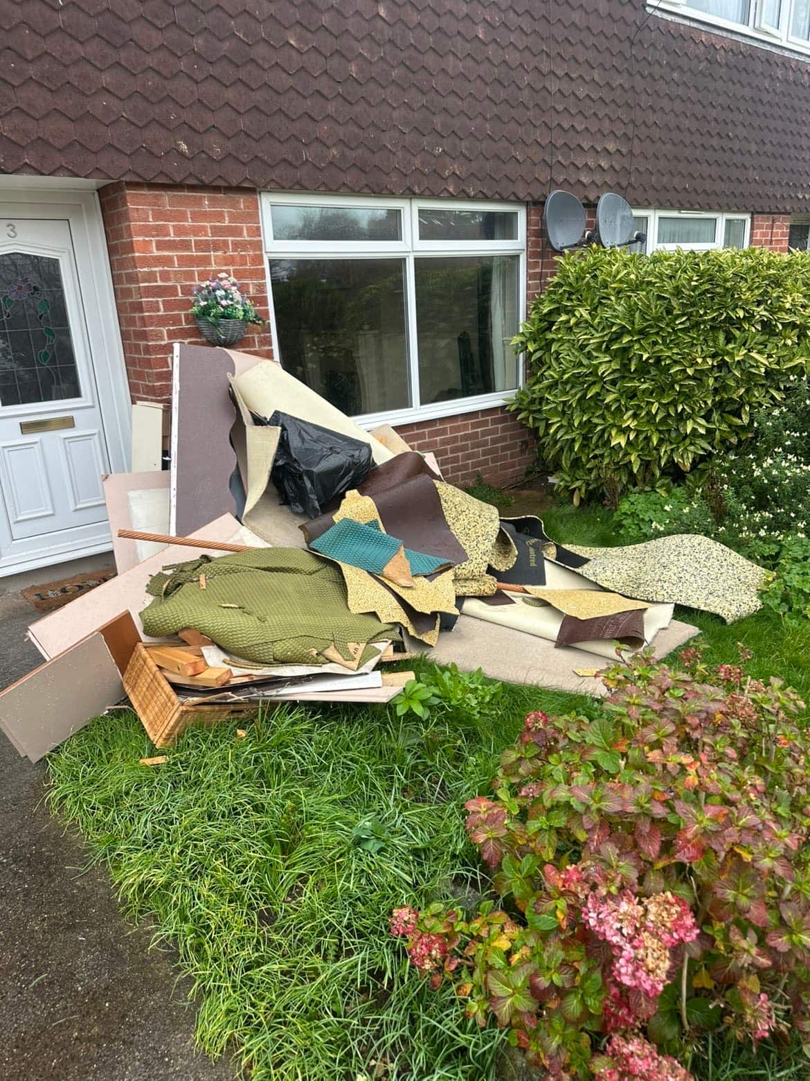 Ripped-up carpet and underlay stacked in a front garden awaiting collection by Mukin in York