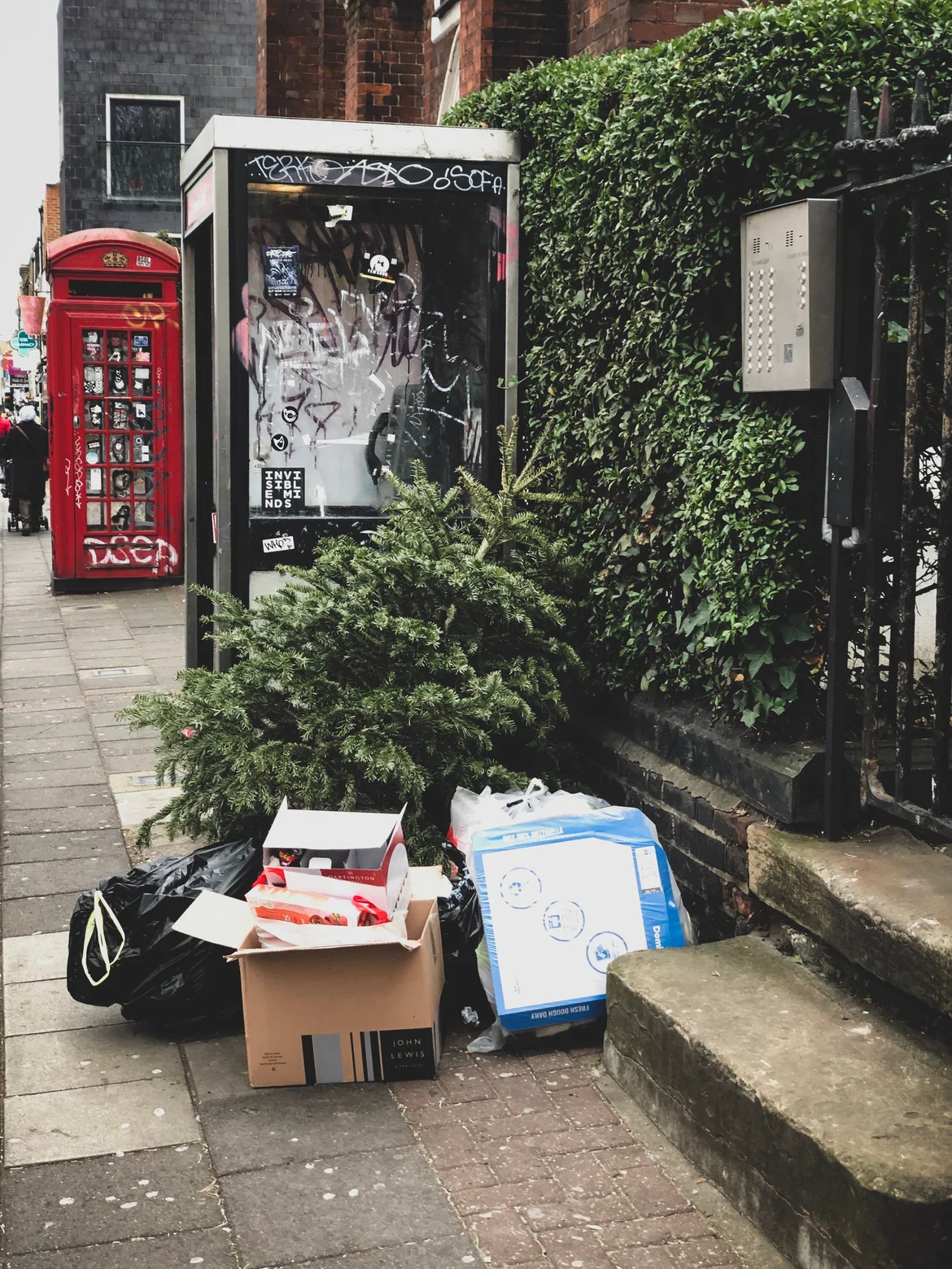 Old Christmas tree left on a pavement with boxes and bin bags after Christmas