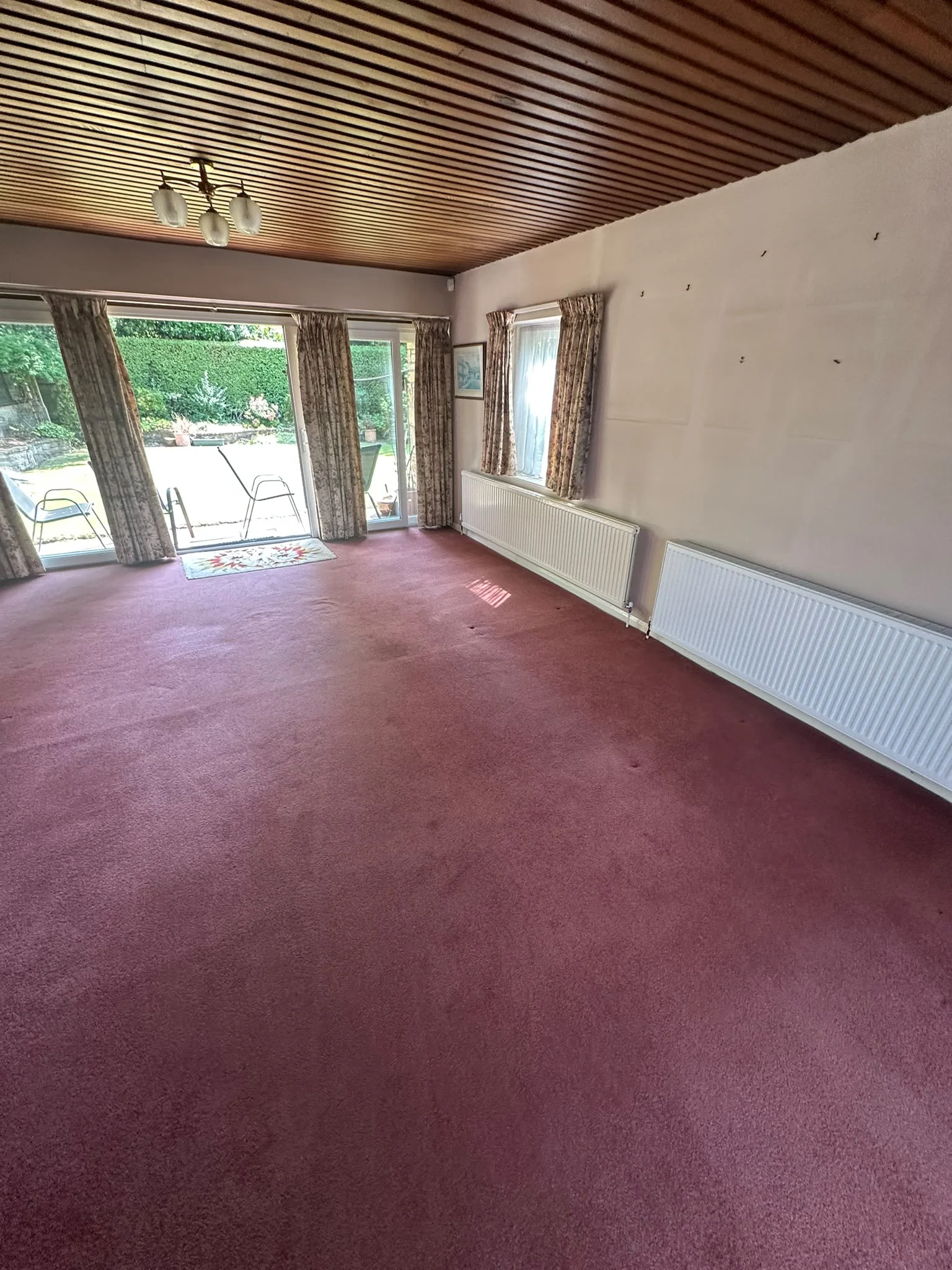 Empty living room after a York house clearance by Mukin, cleared back to bare carpet and stone fireplace